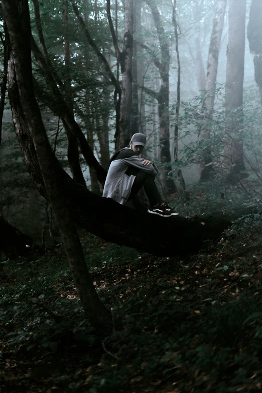 a man is sitting in the middle of the woods