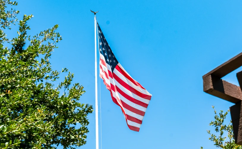 a flag on top of a wooden chair next to a tree