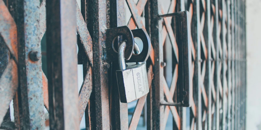 a padlock that is mounted on the back of a gate