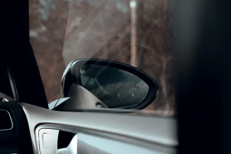 a side view mirror and a car with it's head up