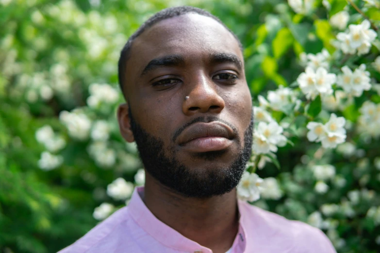 the man is standing in front of some flowers