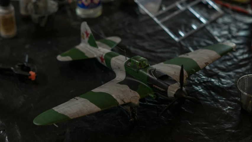 the model airplane is green and white on the table