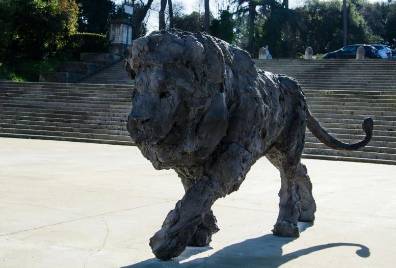 the statue of a lion is displayed in front of some stairs