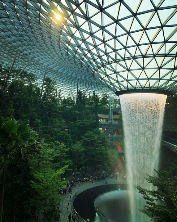a fountain inside a giant tropical building