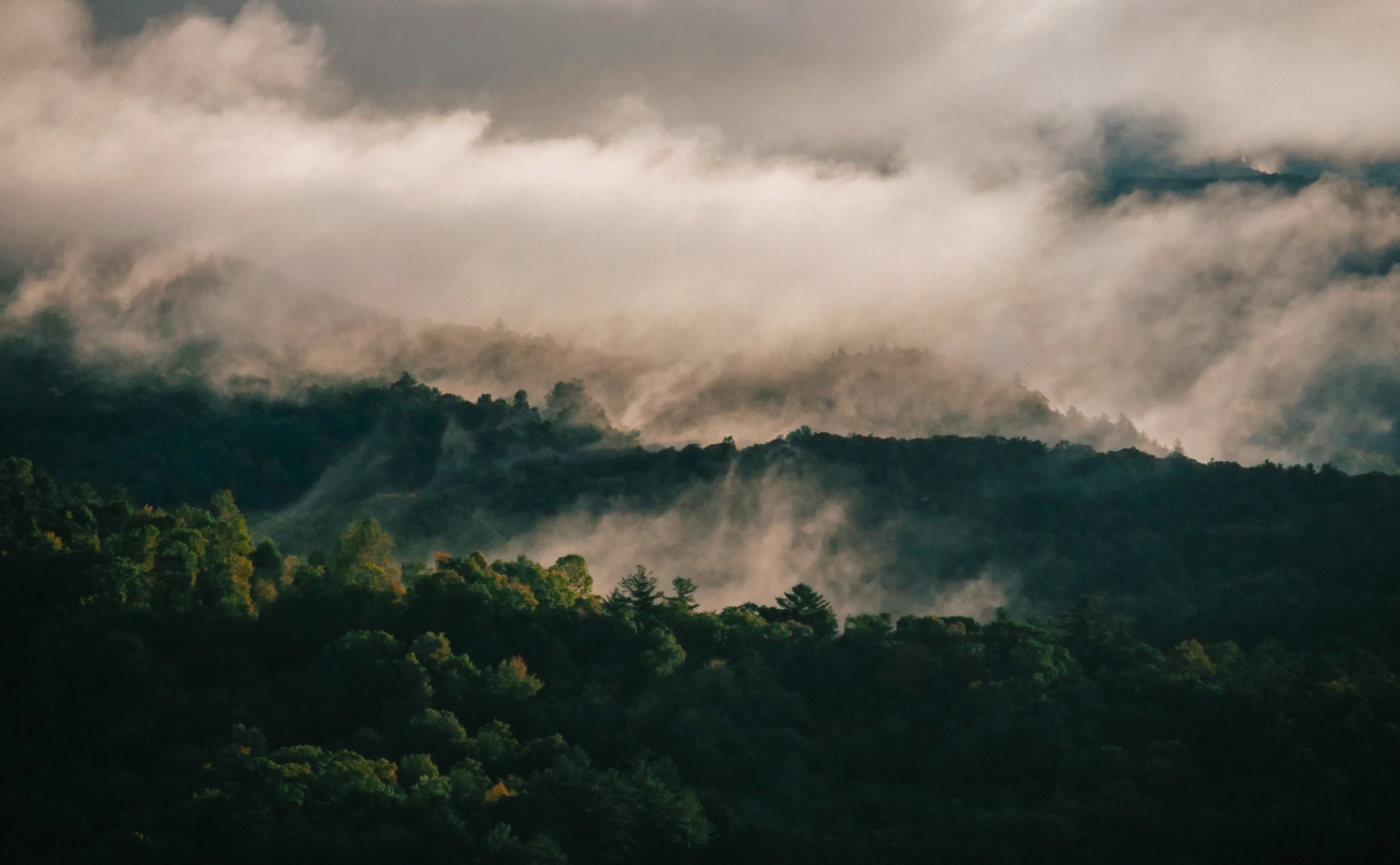 foggy clouds roll over the hills on a dark day