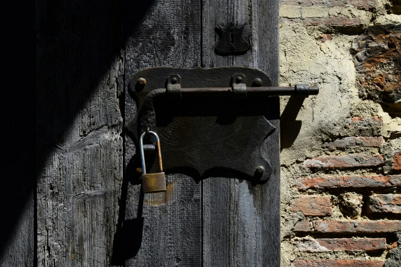 a keyed padlock hangs from a wooden door