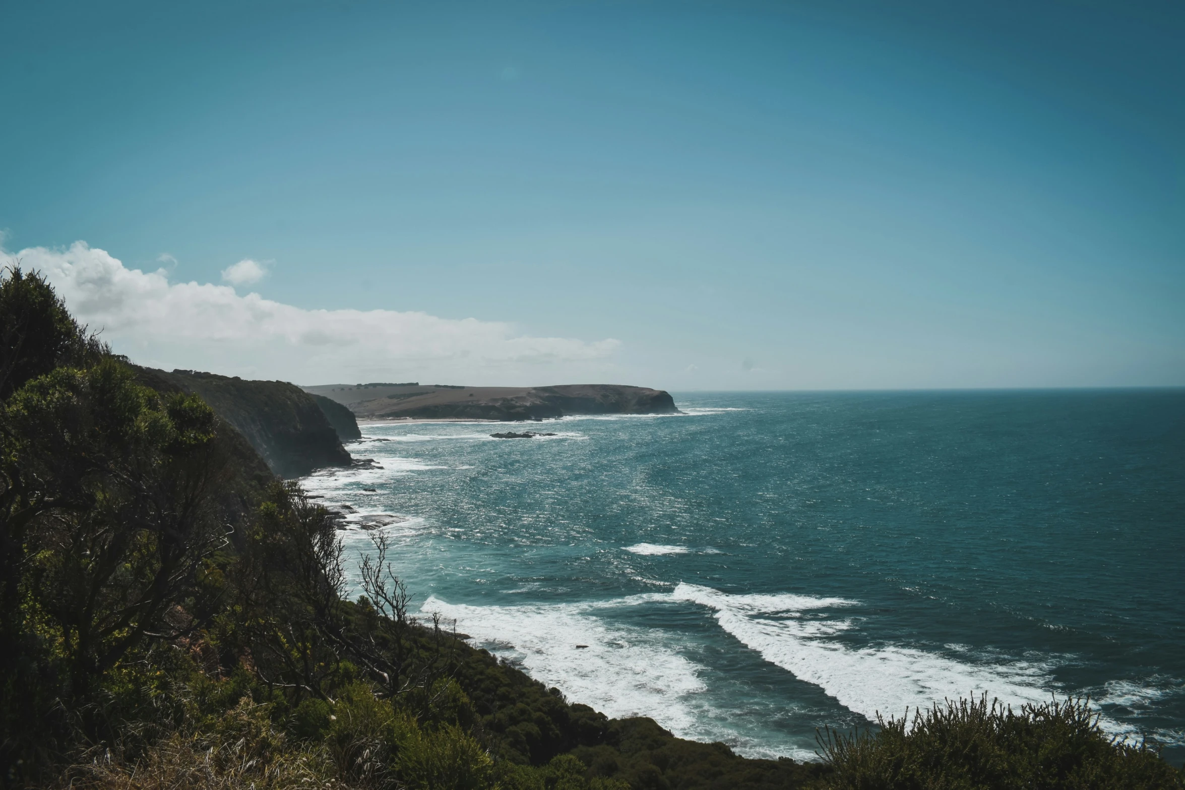 the ocean is blue with small waves coming in