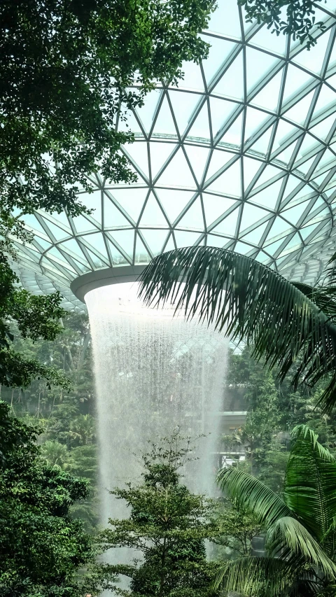 a water fall in the middle of a tree covered park