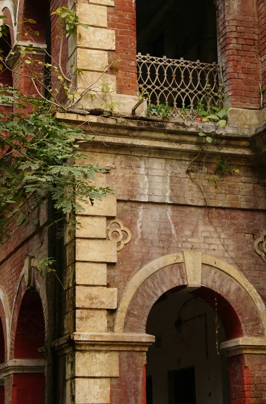 an old building with the doors open and leaves hanging from it