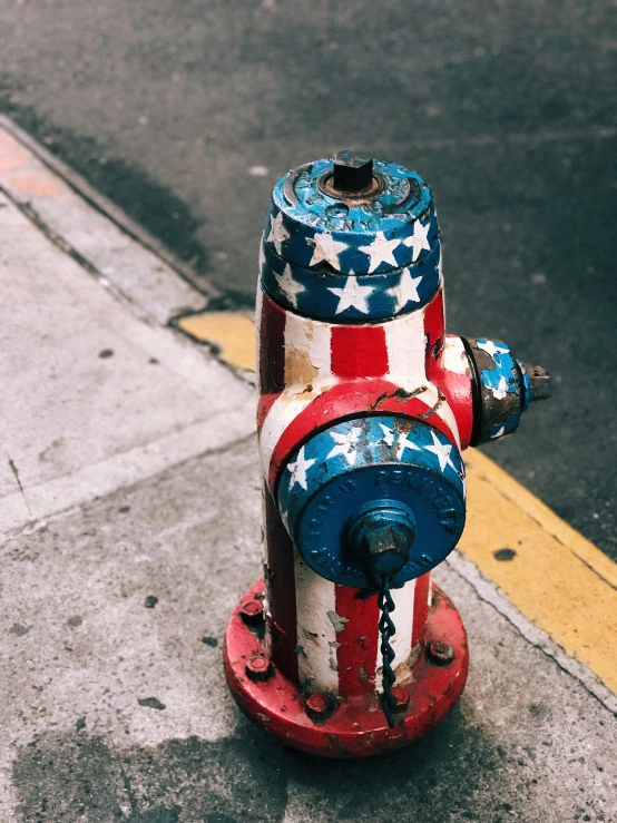 a fire hydrant that has stars and stripes painted on it