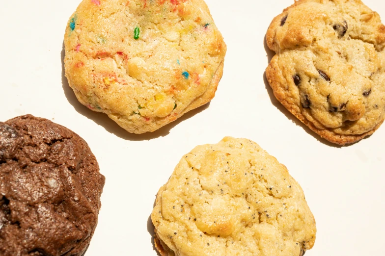 four cookies, one white with chocolate, one speckles, and one brown