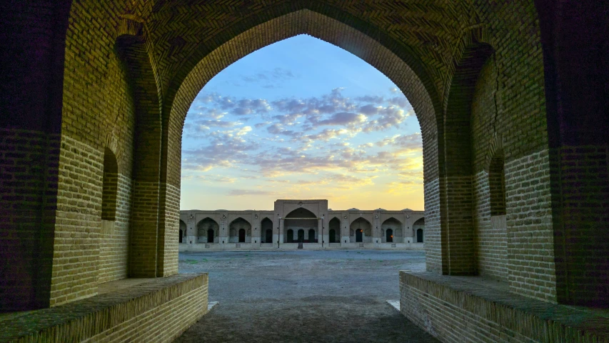 an archway leads to a sunset and a courtyard