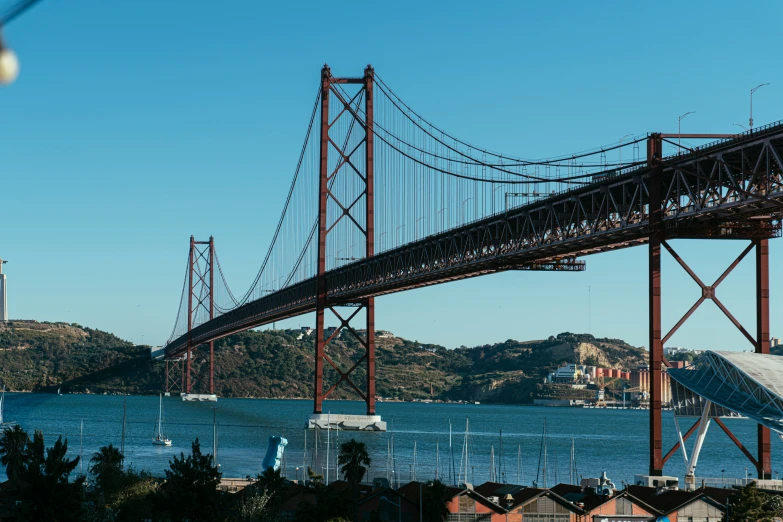 a bridge spans into the water with some hills in the background