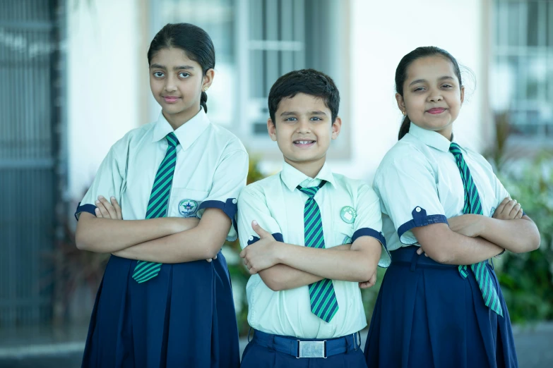 three children wearing uniforms posing for a po