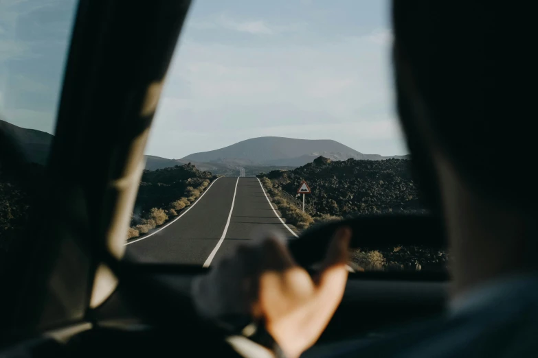 two people riding on their car driving on a road