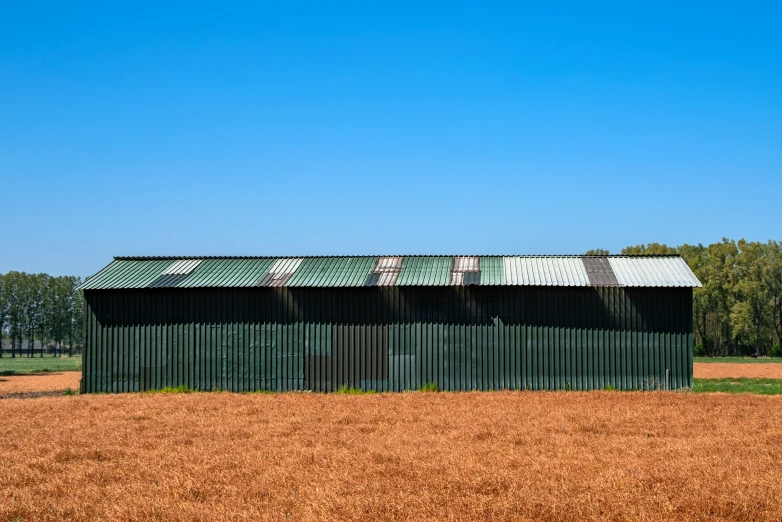 a small green building with a rusted metal roof