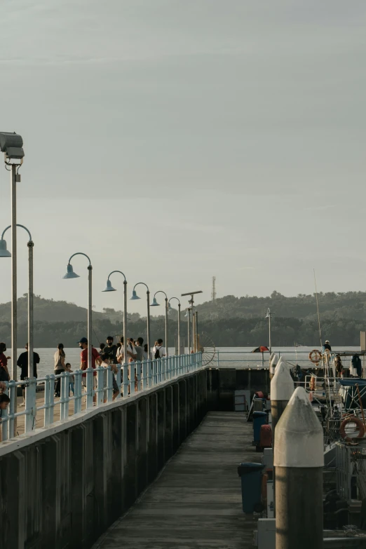 people walk on a walkway next to the water