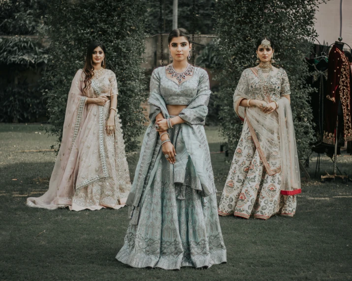 three woman wearing traditional indian outfits, one in light blue