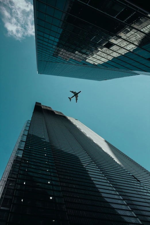 a commercial plane flying through the sky over skyscrs