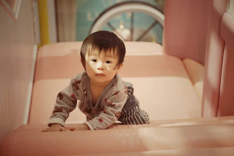 a baby boy is sitting on a pink couch