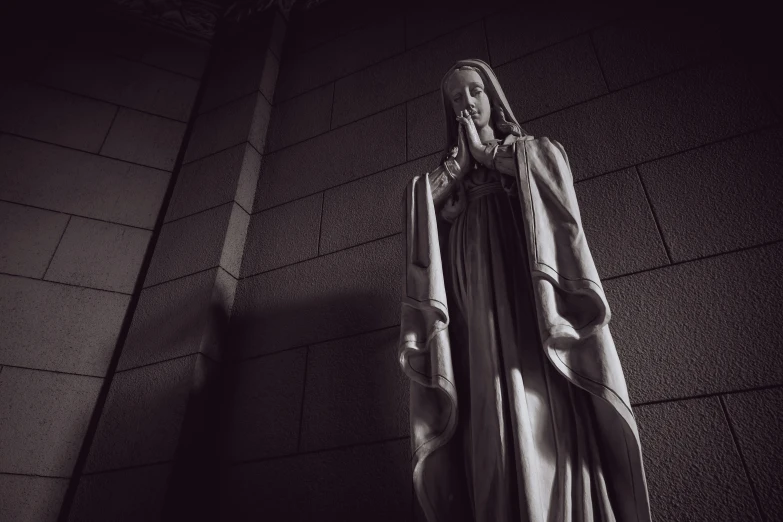 a statue sitting on top of a brick wall