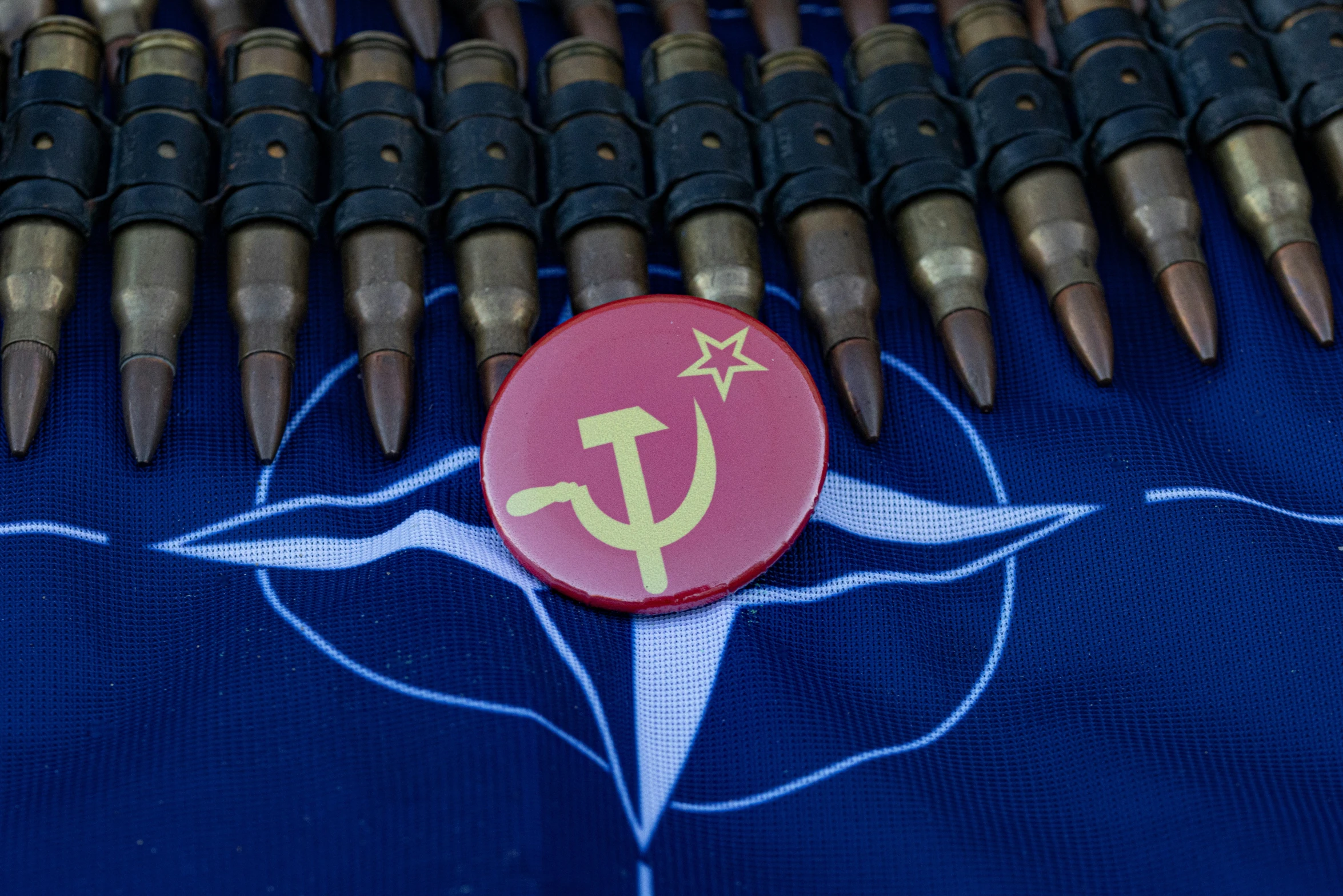 a red on with gold anchors is laying on a purple and blue cloth