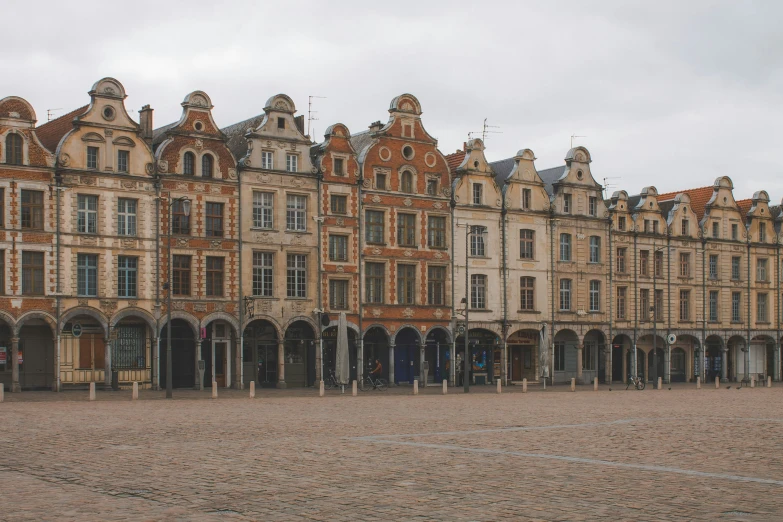 an old building made of stone is on a cobblestone lot