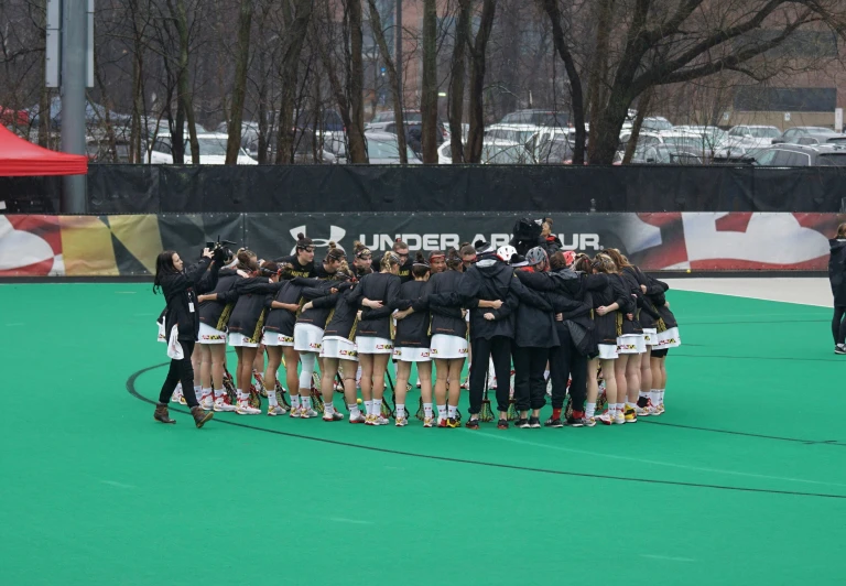 a large group of people standing together on top of a green field