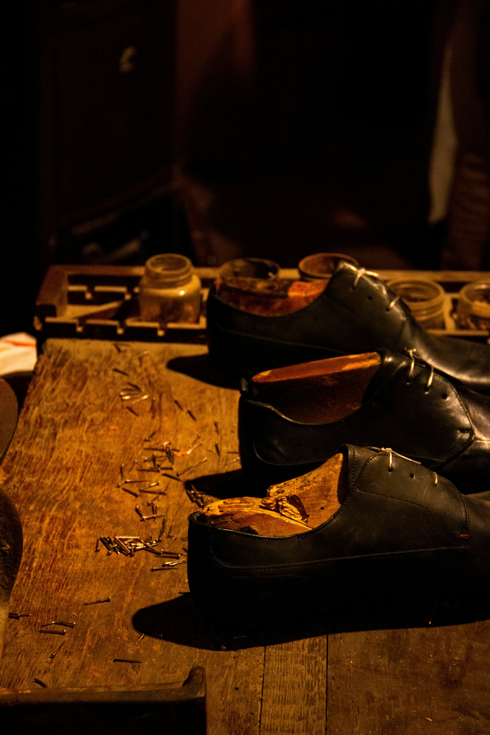 three black shoes sit on top of a wooden table