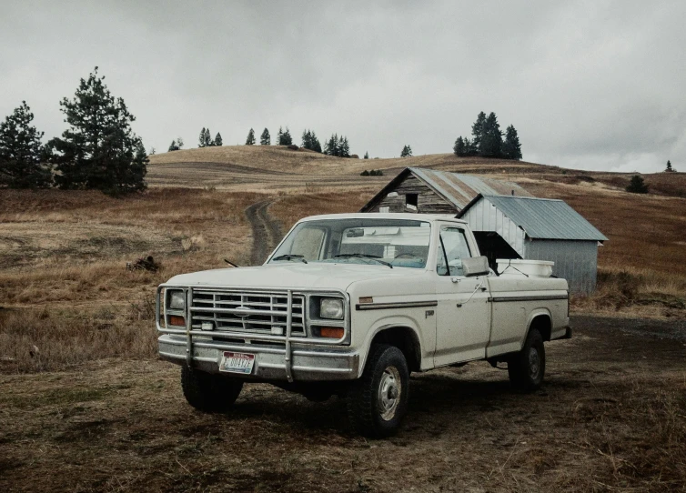 an abandoned truck is parked near the side of a field