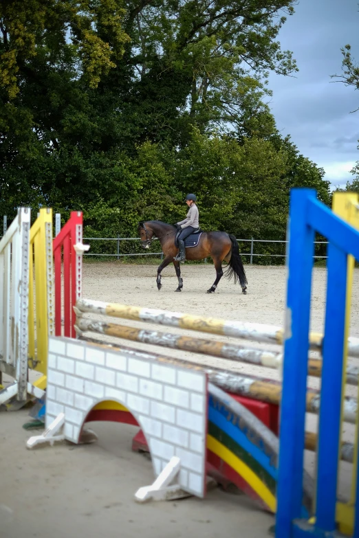 a man riding a brown horse over a wooden bridge