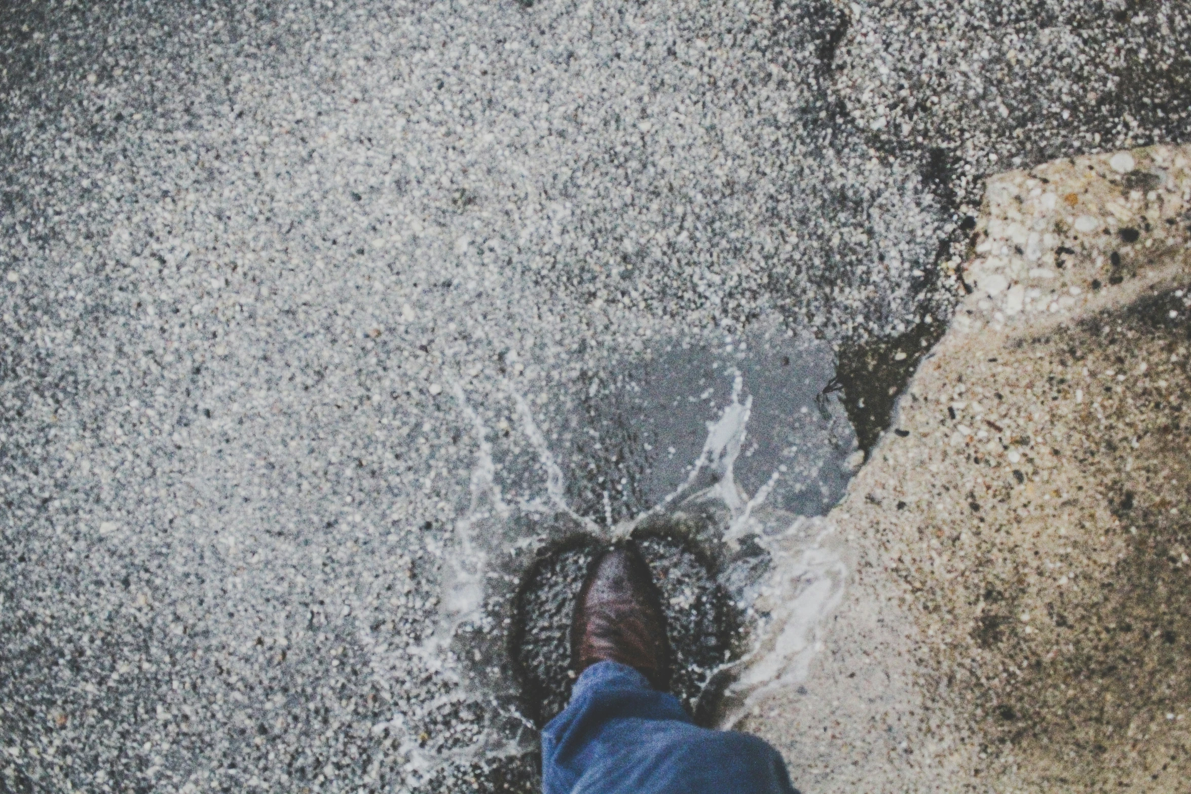 a close up view of someone walking on a wet surface