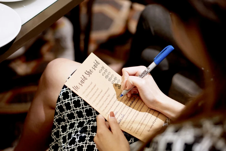 a woman writing in a menu and taking notes