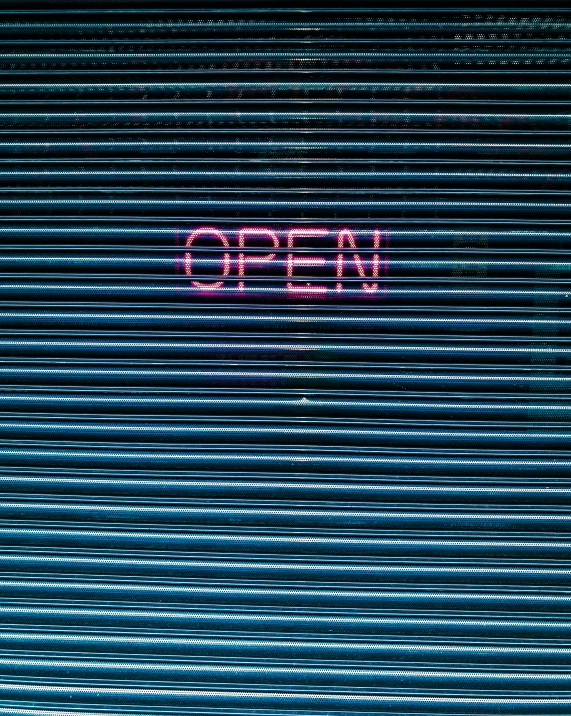 red neon on a brick wall reads open