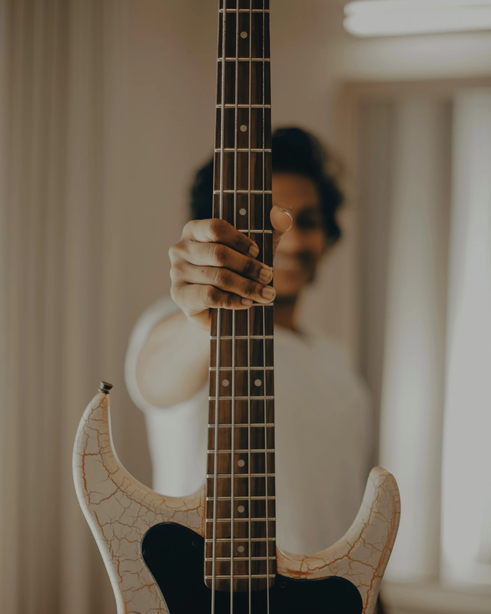 a close up of someone holding a bass guitar