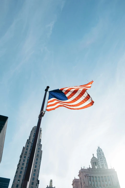 the american flag is on display on top of an pole