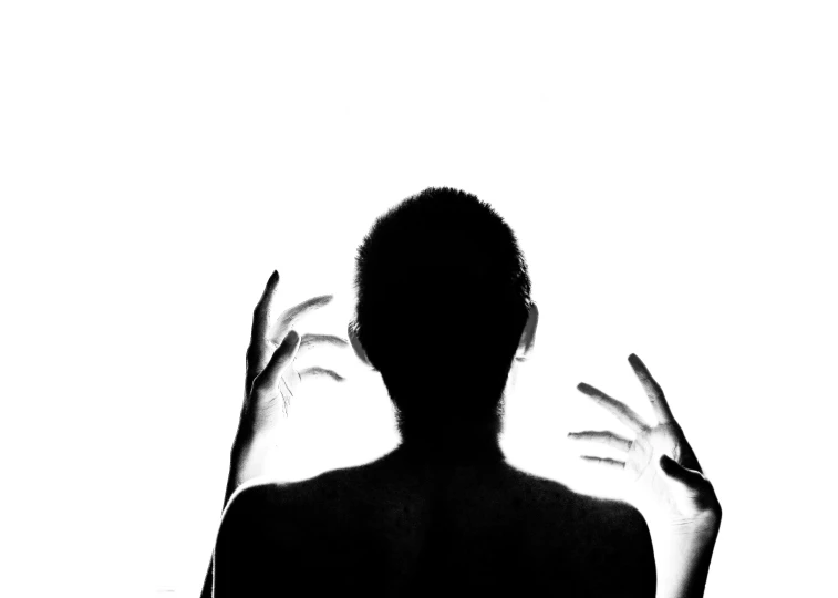black and white picture of an person covering their face