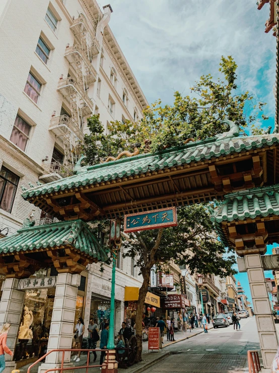 a woman is walking in an ornate arch by a busy street