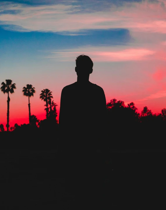 a man standing on the beach while looking out into the distance