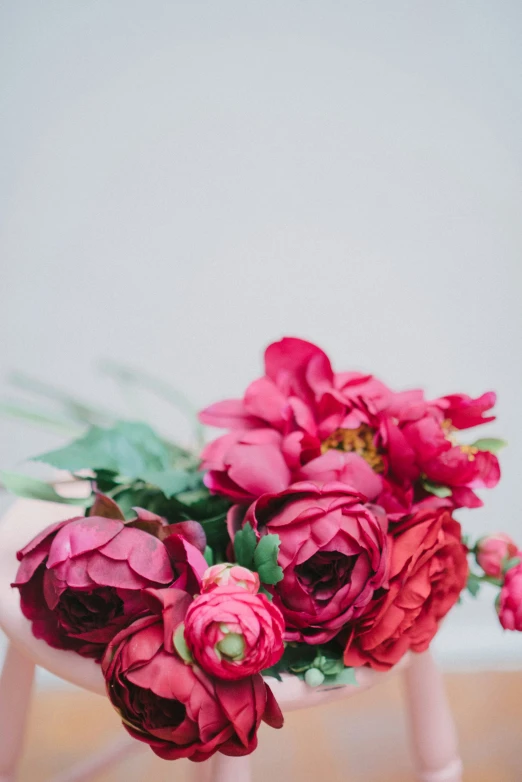 this is a bouquet of roses in an miniature chair