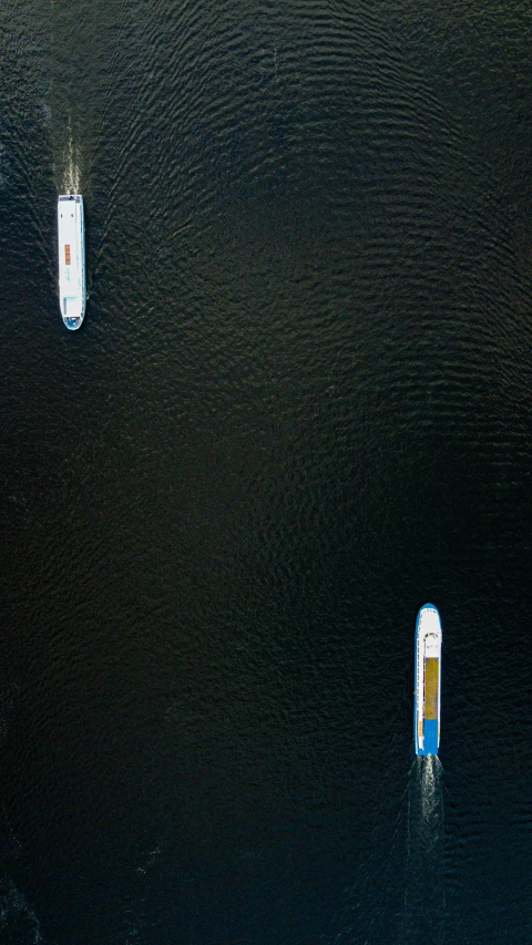 two boats on the water, one is blue and one is white