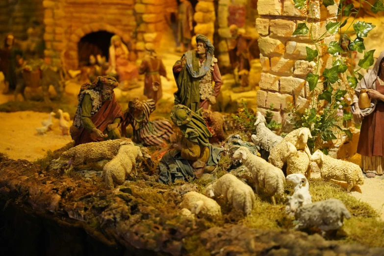 a figurine is displayed in front of a manger scene with many sheep