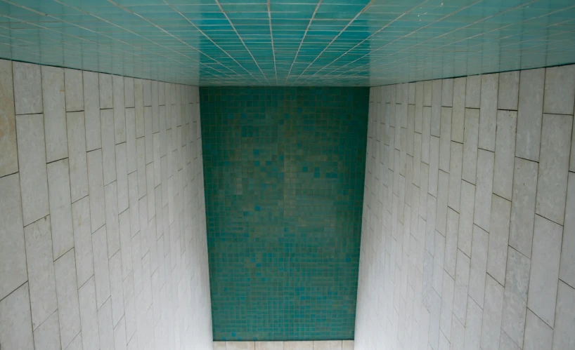 a blue tiled bathroom with only the floor and wall removed