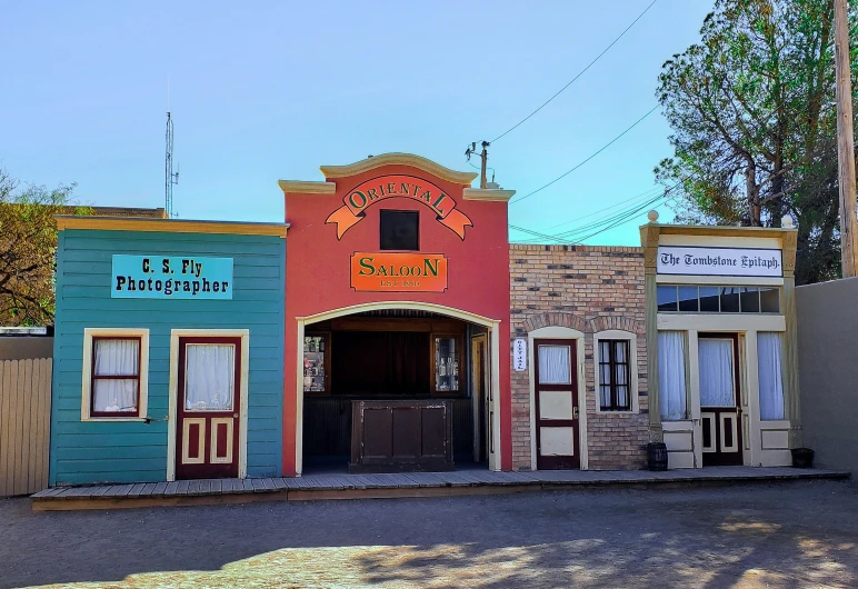 a number of small multicolored buildings in front of a small car