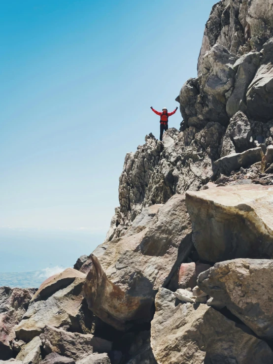 a man that is standing on a rocky hill