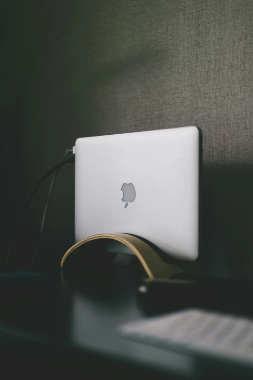 the white apple laptop is placed on the desk