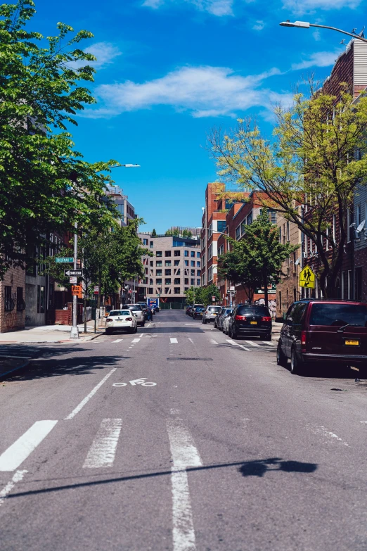 an empty street with two cars parked on the side of it