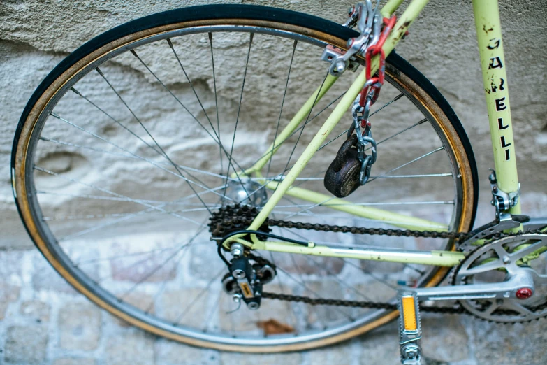 a bicycle leaning against a wall, with a helmet hanging from the bike handle