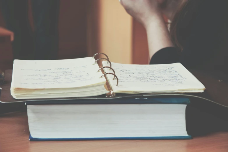 a person with a ring looking at a notebook