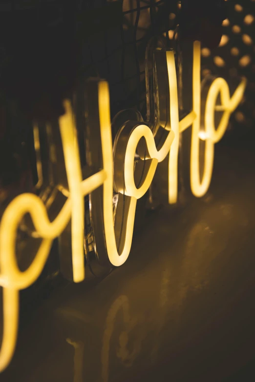 a yellow neon sign hanging from a wall